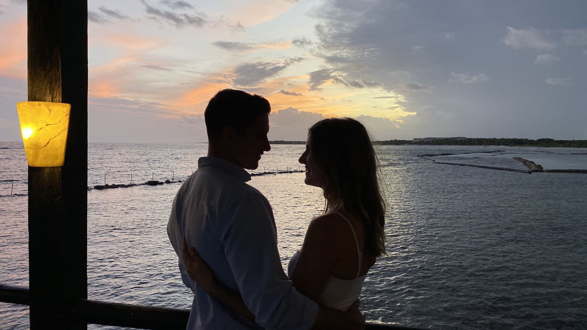 Silhouette of a couple on a pier at sunset