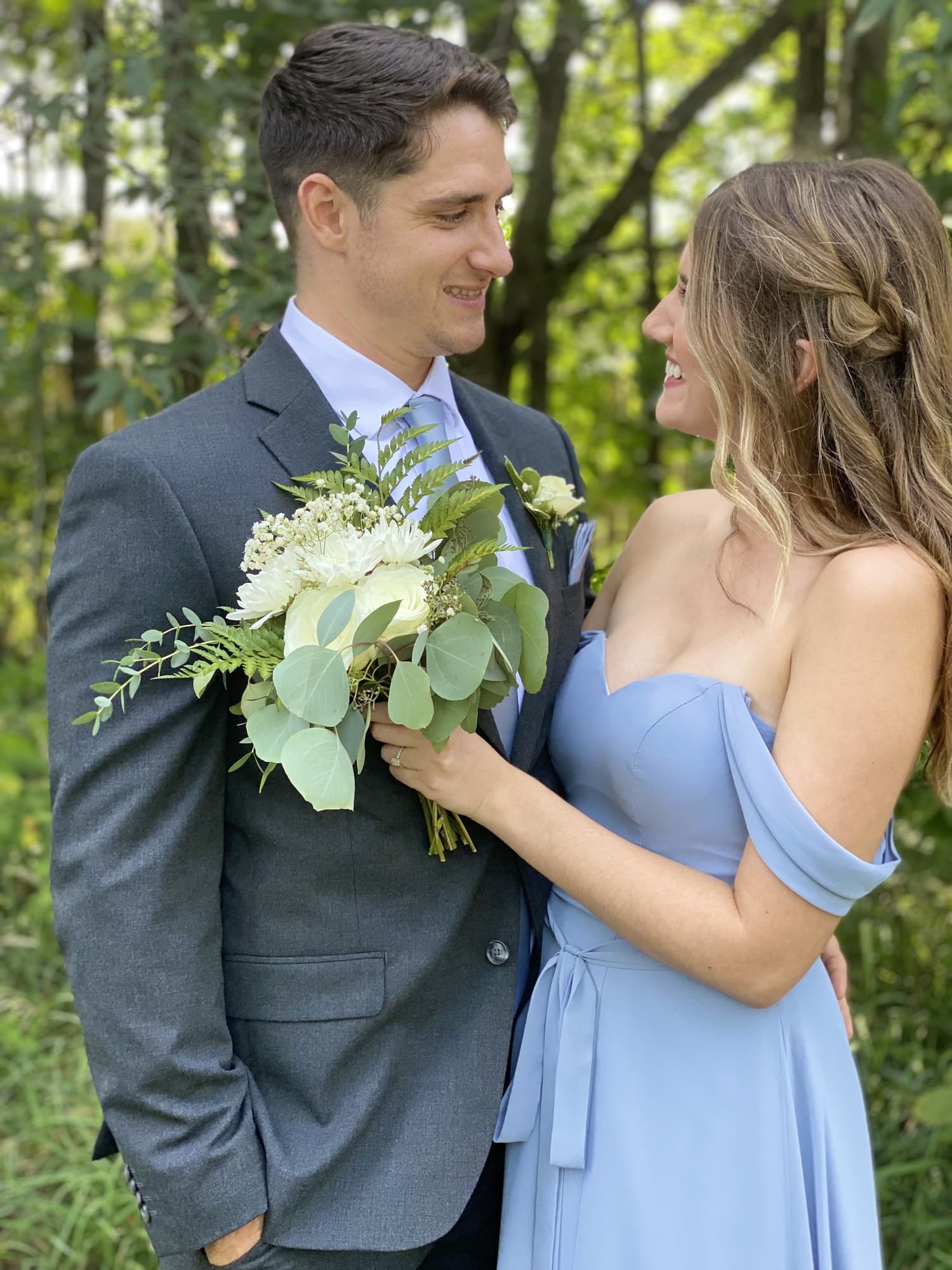 Couple smiling at each other in a lush garden